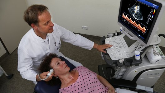 Prof. Dr. med. Rüdiger Hilker-Roggendorf bei der Ultraschalluntersuchung der Schläfe 